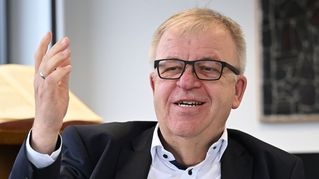 Pastor Pohl spricht mit erhobener Hand.