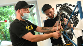 Two men repair a bicycle