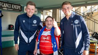 Arminia-Fan Oliver Kemper posiert mit den Arminia-Profis Lukas Kunze und Mika Schroers.