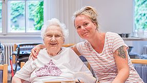 Two women smile into the camera.