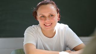 Eine junge Frau sitzt an einem Tisch.