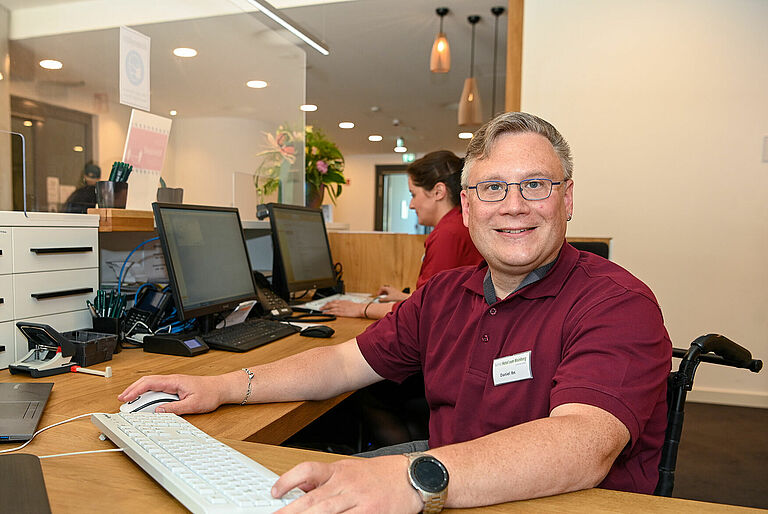 Daniel Ibs sitzt am Hotel-Empfang.