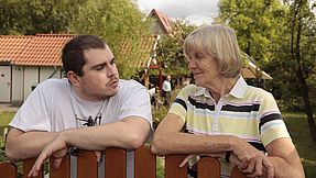 Mann und Frau am Zaun im Schrebergarten