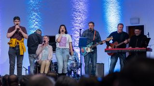 Die Band steht auf der Bühne und performt gemeinsam einen Song.