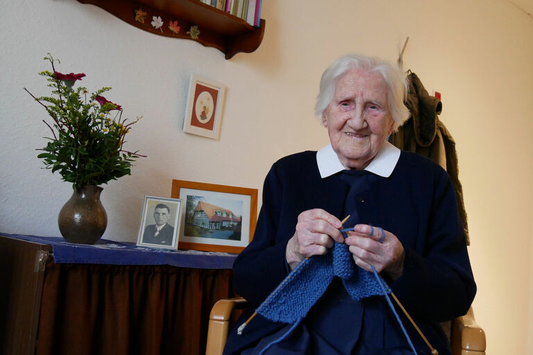 Diakonisse Änne Hauptmeier strickt in ihrem Zimmer.