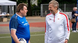Guido Buchwald im Gespräch mit einem Fußballer.