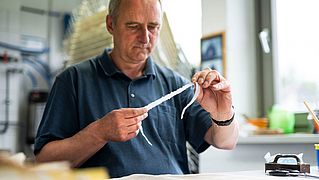 Burkard Goette arbeitet konzentriert an seinem Schreibtisch.