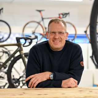 Mann lächelt in einem Fahrradladen.