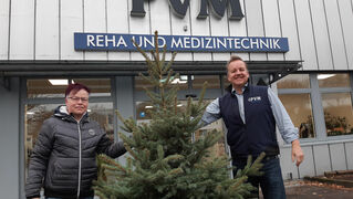 Martina Reuter, Bethel, und Markus Wendler, PVM, mit einem Weihnachtsbaum. Der steht zwischen den Personen.