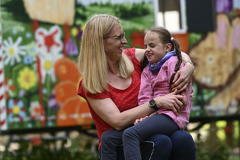 Kind auf Schoß der Mutter im Kinderhospiz