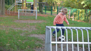 Junge spielt Fußball im Garten der Kinder- und Jugendpsychiatrie