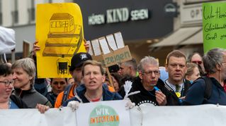 Männer und Frauen halten Plakate hoch