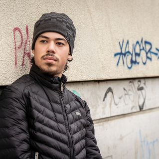 Mann lehnt sich gegen eine Wand.