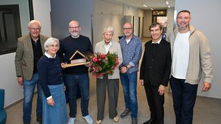 Gruppenbild: Leitende übergeben einen Blumenstrauß an die Großspenderin