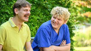Jonah Lochmüller sitzt zusammen mit einem Klient im Garten.