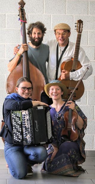 Vier Musiker stehen auf dem Bild mit ihren unterschiedlichen Instrumenten