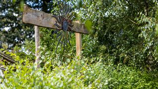 Eine Blechsonne auf Holz schmückt das Hofgelände.