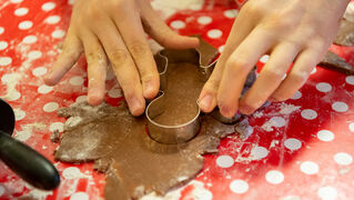 Hands cut out biscuits with mould.