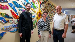 Gruppenbild vor bunter Wand im Kinderhospiz