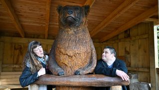 Stefanie Wiegmann und Angelo Napoletano stehen neben einer großen Bärenfiguar.