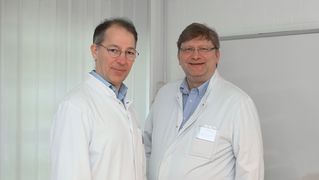 Dr. Thilo Kalbhenn und Prof. Dr. Matthias Simon lächeln in die Kamera 