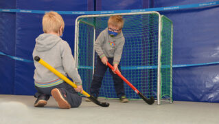 Zwei Jungs spielen Hallenhockey in der Kinder- und Jugendpsychiatrie