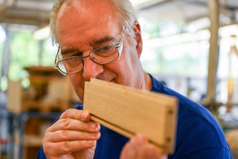 Ein Mann überprüft ein Holzstück.