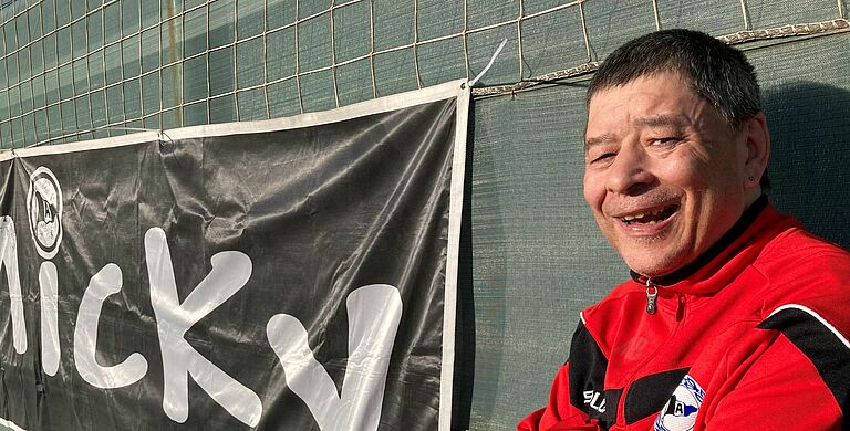 Micky steht neben seinem Banner.