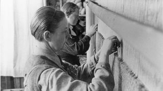 Frauen knüpfen am Webrahmen.